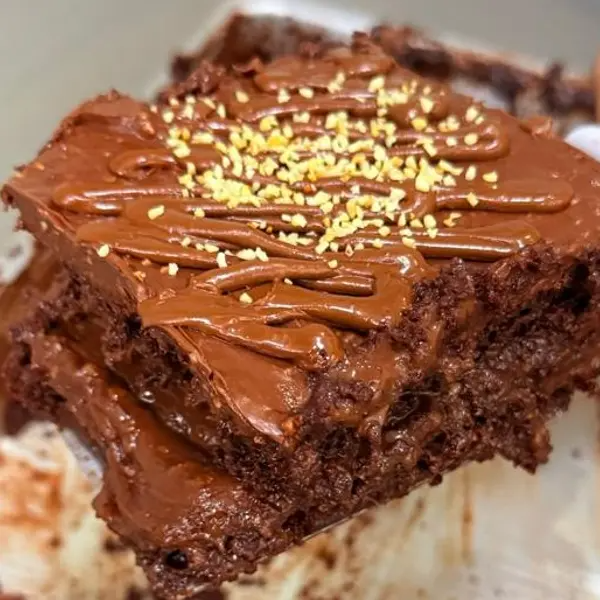 Base de chocolate intensamente úmida, combinada a um recheio cremoso de brigadeiro de Ferrero e creme de avelã enriquecido com pedaços de castanha. A finalização traz uma ganache meio amarga e castanhas, equilibrando doçura e intensidade.