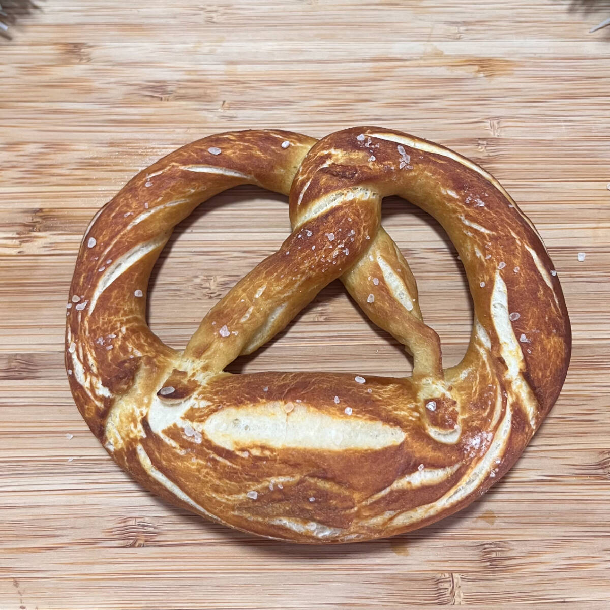 Brezel salgado, artesanal, massa de pão, macia por dentro e dourada po fora, levemente salgada com cristais de sal grosso, fermentação natural, receita alemã