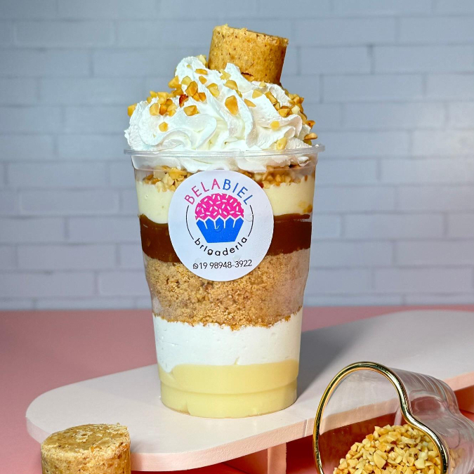 Camadas generosas de doce de leite cremoso e nosso famoso brigadeiro de Ninho. Para trazer textura, adicionamos paçoca esfarelada e o "crunch" do amendoim torradinho. Tudo isso intercalado com um mousse de Ninho leve e finalizado com uma nuvem de chantilly sedoso. É a sobremesa perfeita para quem ama sabores intensos e texturas crocantes!