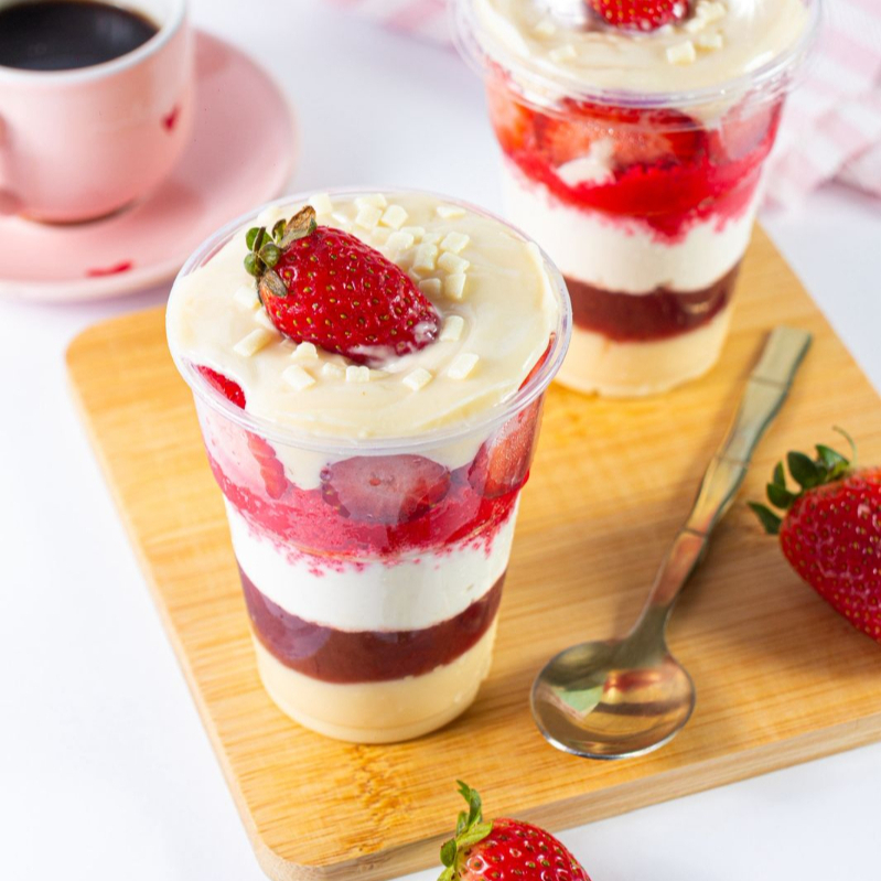 Um delicioso copo da felicidade red velvet com nosso famoso brigadeiro de Ninho e nossa geleia de morango caseira e morangos picados.