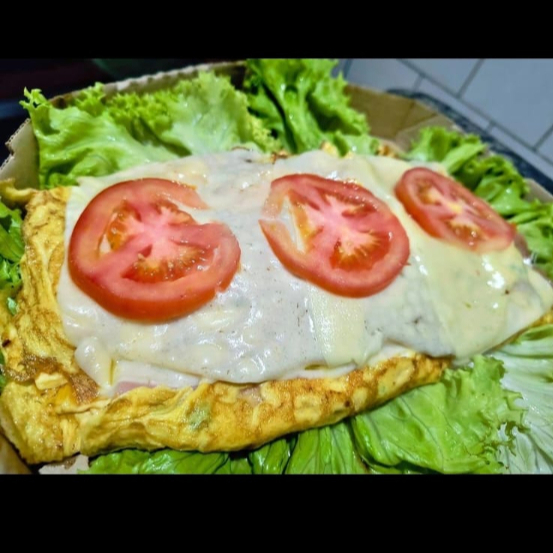 Ovos batidos com toque de orégano recheado com presunto, mussarela, orégano finalizado com mais mussarela e tomate