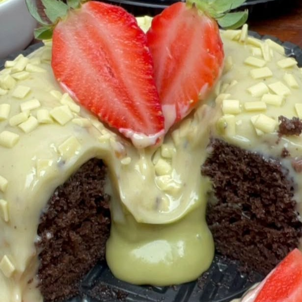 Bolo vulcão com massa de chocolate ou baunilha fofinho, com brigadeiro de pistache e finalizado com morango para decorar.