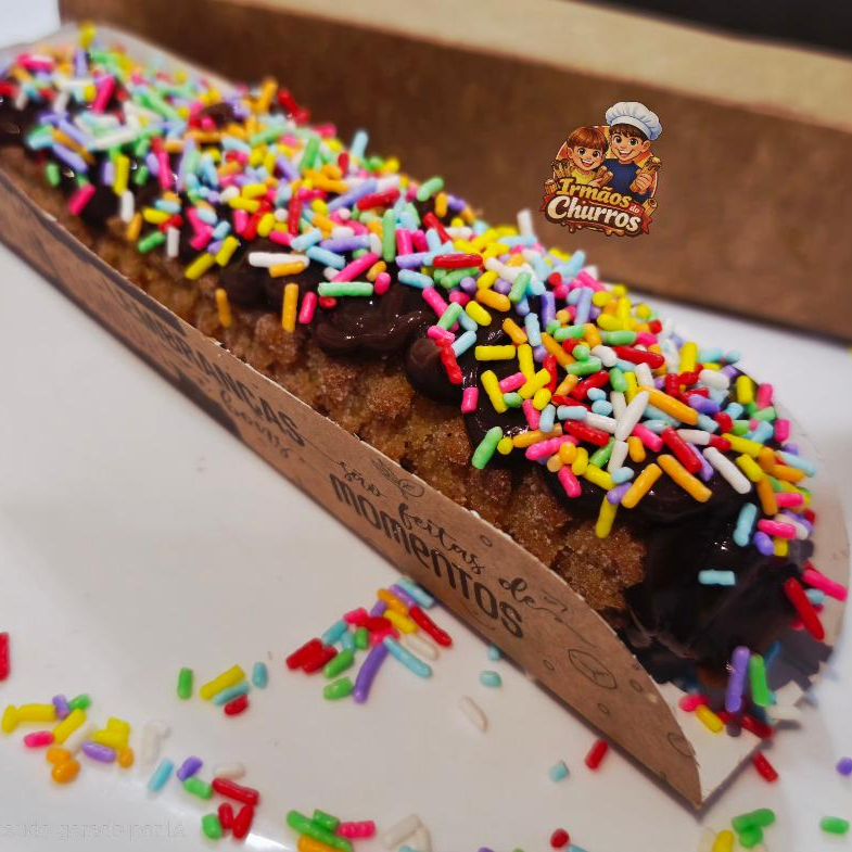 Delicioso churros gourmet salpicado com açúcar de confeiteiro e canela em pó com recheio e cobertura de doce de leite ou doce de chocolate coberto com Granulado colorido.