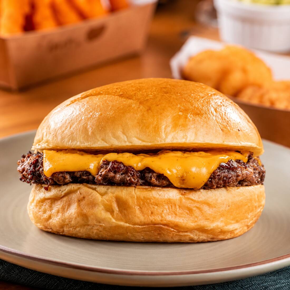 Pão de brioche com blend burguer bovino(80g), fatia de cheddar derretido e maionese da casa. Um Smash simples, uma opção bem montada, com destaque para a cremosidade do cheddar.