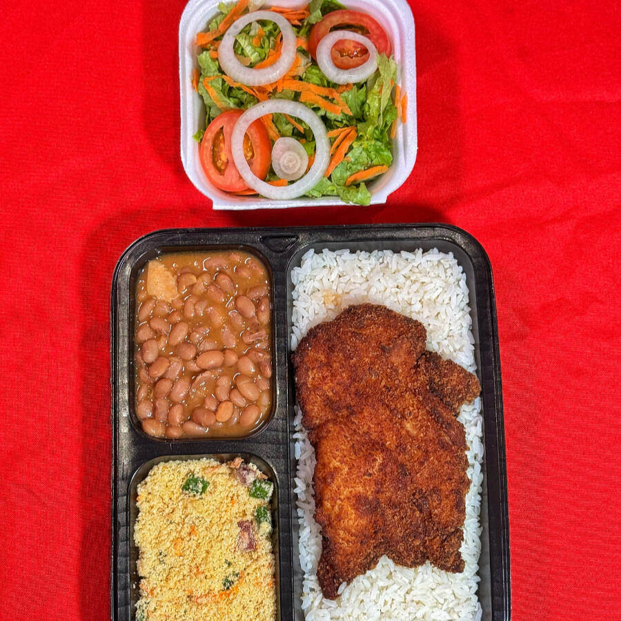 Arroz soltinho, feijão caseiro, bife de contra filé à milanesa, farofa especial e salada com alface, tomate, cebola e cenoura. Um prato completo, saboroso e com aquele toque de comida feita com carinho.