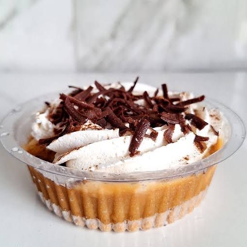 Uma deliciosa combinação de camadas de biscoito crocante, doce de leite cremoso, rodelas de banana fresca e uma suave cobertura de chantilly, finalizada com um toque de  granulé