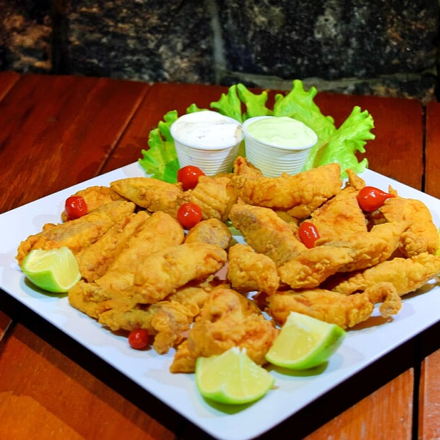Filezinho de tilápia fatiado e empanado servidos com molho especial da casa