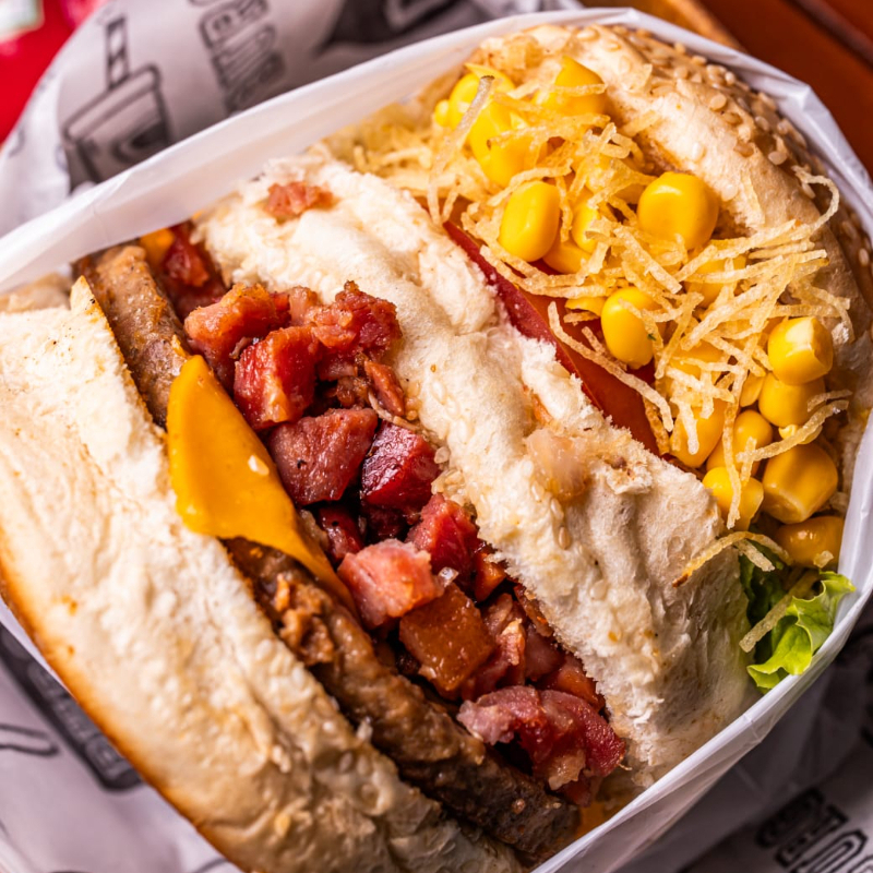 X Bacon ( pão artesanal, suculenta carne de hambúrguer bovino, porção generosa de bacon, queijo prato derretido, batata palha fina crocante, milho verde, alface crespa e tomate fresco) FRETE GRÁTIS para primeira compra na loja