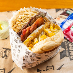 Pão, carne, salsicha, ovo, mussarela, presunto, alface, milho e batata palha.