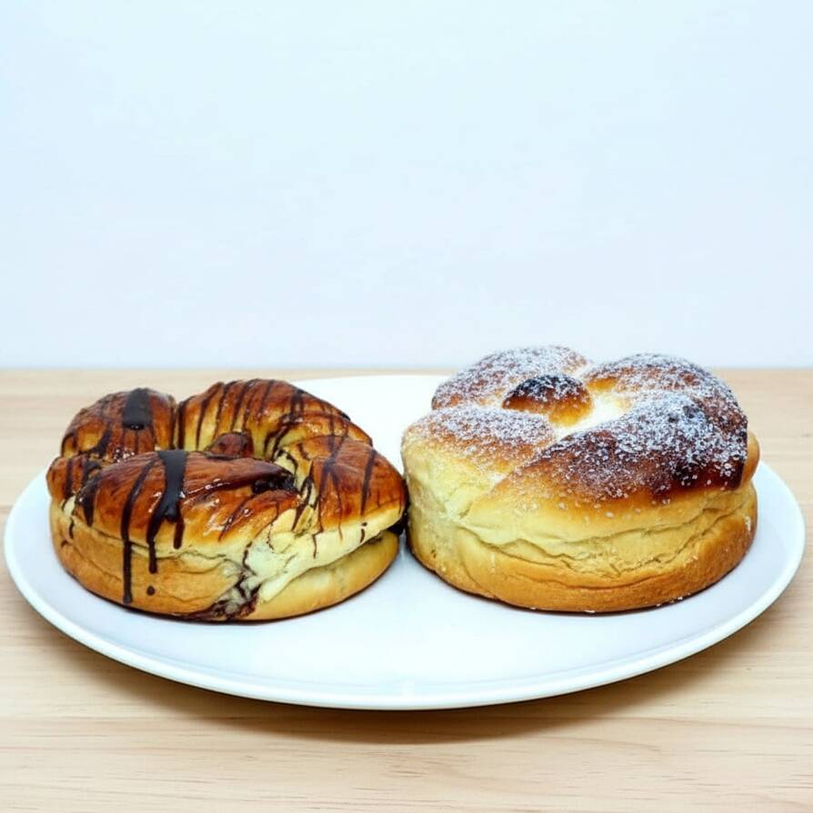 Macia, fofinha e irresistível! Nossa Rosca Doce é preparada com uma massa leve e dourada, recheada com um delicioso creme de chocolate que garante muito sabor em cada fatia. Perfeita para o café da manhã, lanche da tarde ou para compartilhar com a família. Feita no estilo caseiro, combina textura macia, recheio generoso e aquele gostinho de padaria que conquista desde a primeira mordida. Com aproximadamente 500g por unidade, é a escolha perfeita para quem ama doces fresquinhos e cheios de sabor. Peça agora e experimente!
