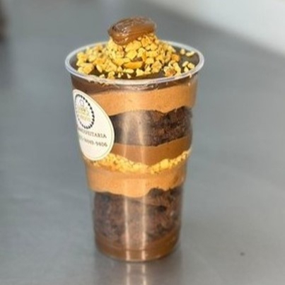 Feito com mousse de chocolate, brigadeiro gourmet, amendoim crocante, Nutella e brownie, essa combinação única é finalizada com um brigadeiro tipo Ferrero, criando uma explosão de sabores irresistíveis. - APROX. 250GR