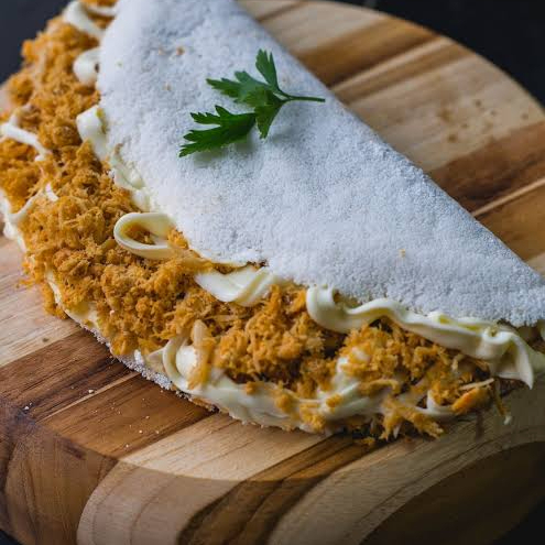 Tapioca leve e macia, feita na hora com frango desfiado super temperado e bem recheado. Sabor caseiro irresistível!