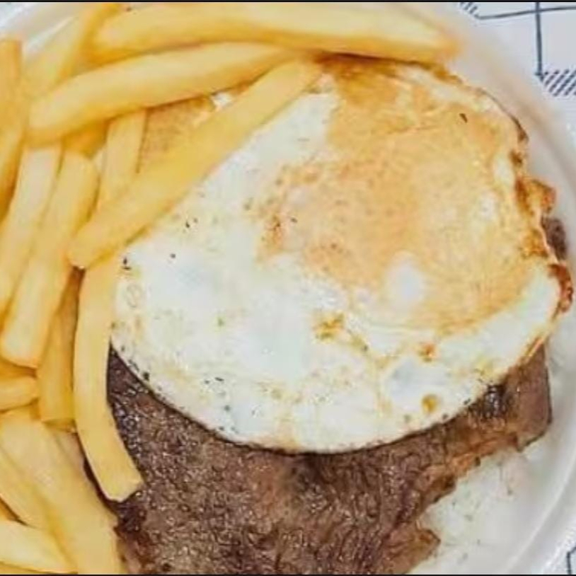 A marmita acompanha arroz, feijão, contra acebolado, ovo e fritas.