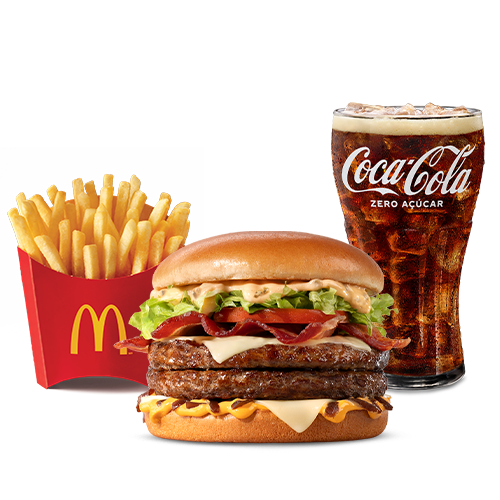 Dois hambúrgueres de carne 100% bovina, méquinese, a exclusiva maionese especial com sabor de carne defumada, alface e tomate, fatias de bacon, queijo processado sabor emental, molho especial e cebola ao molho shoyu, tudo isso no pão tipo brioche trazendo uma explosão de sabores pros seus dias de glória! Acompanhamento e Bebida.