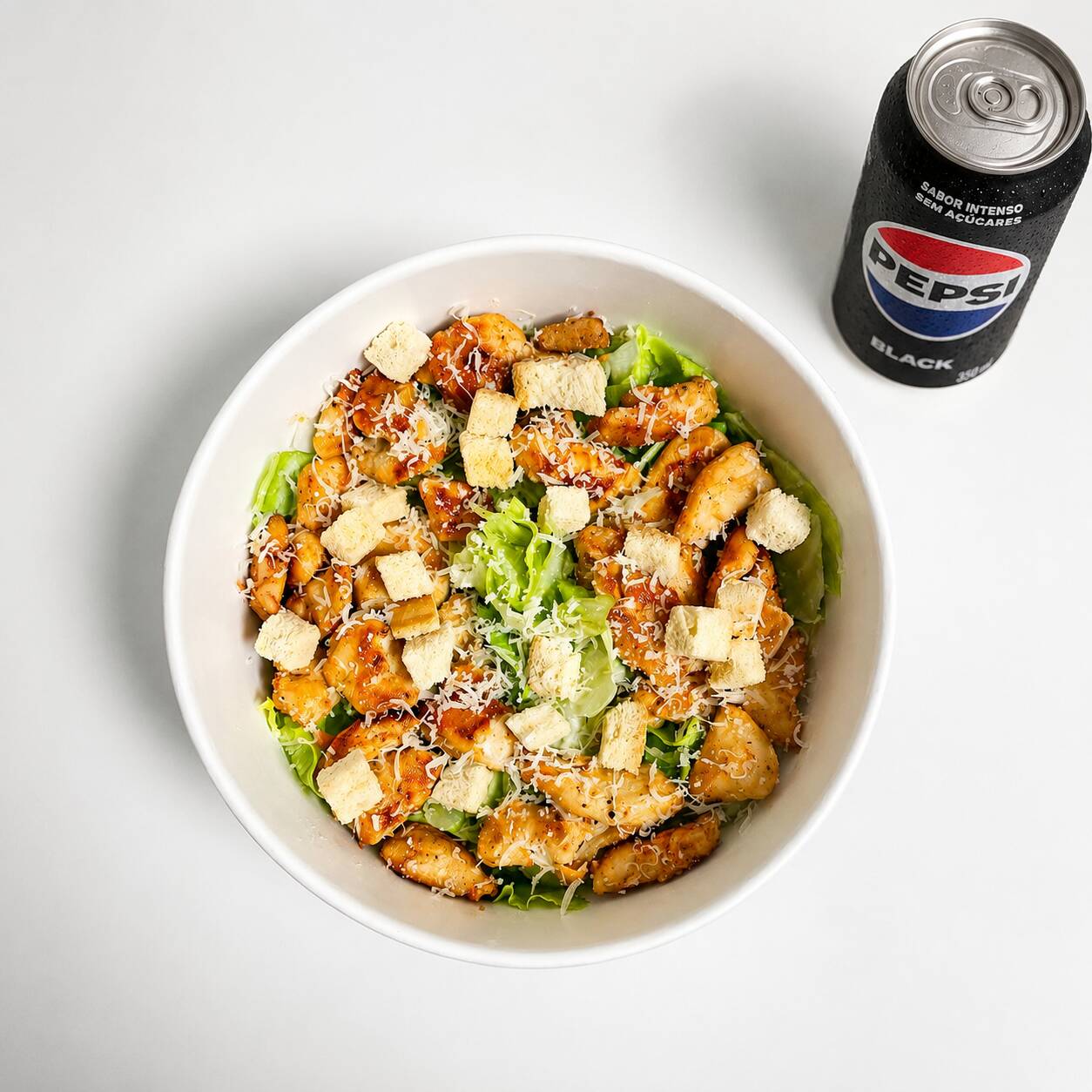 Uma combinação leve e saborosa de alface americana, croutons e lascas de parmesão, finalizada com frango grelhado e um molho caesar.