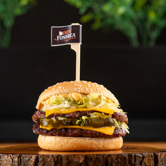 2 hamburgueres 100g feitos no fogo, 2 queijos, alface americana, cebola, picles e molho especial em um pão com gergelim. Tipo aquele famoso do palhaço (só que melhor).