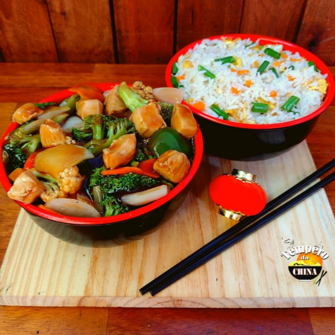 Porção de frango com legumes, acompanhadas de arroz yakimeshi