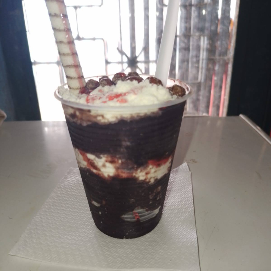 Açaí batido com banana servido com calda e complementos