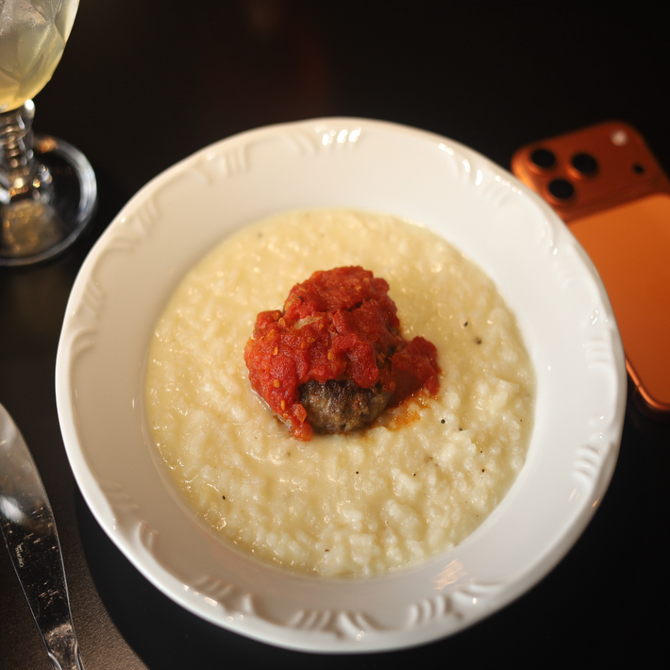 Risoto cremoso, combinação de vinho branco e queijo. Acompanha polpetone