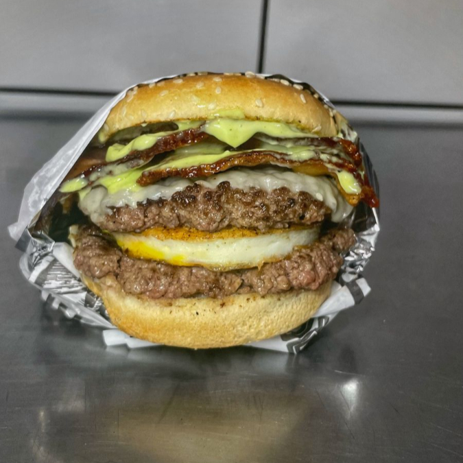 pão gergilim, 2 carne de smash de 60g, queijo derretido no vapor, ovo , fatias de bacon e molho de ervas