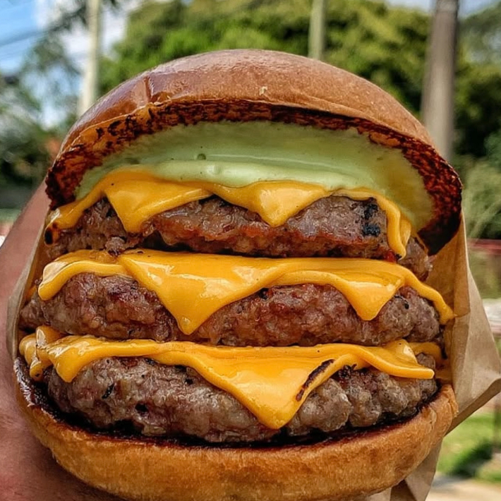 Pao Brioche, 3 blends de 160gr, cheddar fatiado, bacon, alface, tomate, cebola caramelizada e maionese da sua escolha