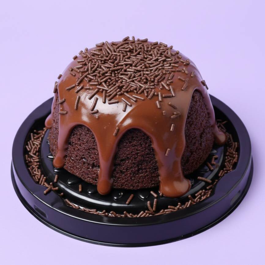 Bolo de chocolate fofinho e finalizado com uma generosa cobertura de chocolate cremoso. Enviamos quentinho. Serve 1 pessoa (aprox. 120g)
