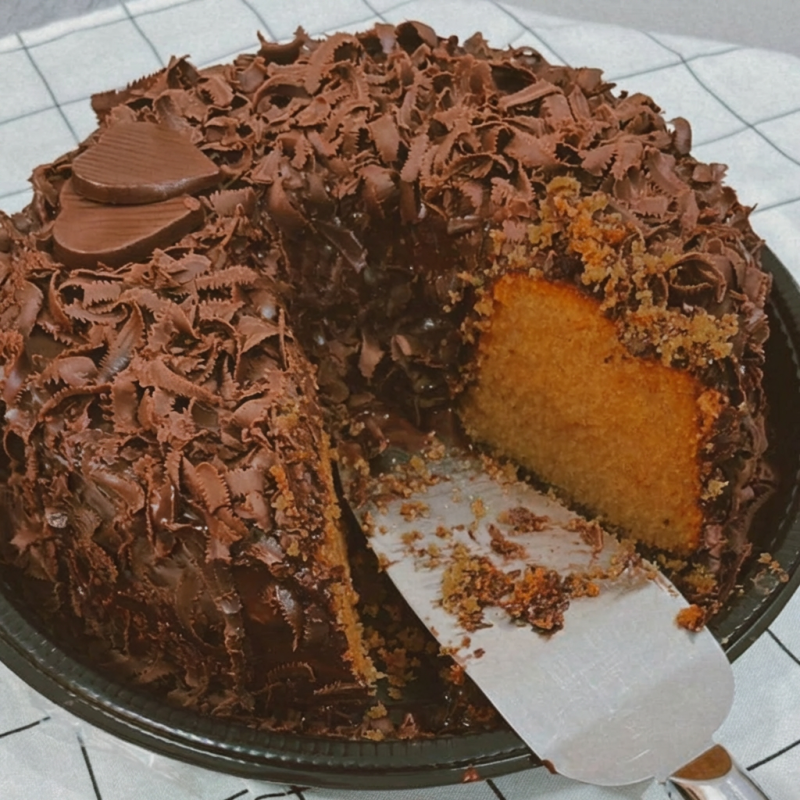 bolo de cenoura artesanal com cobertura de ganache de chocolate e raspas de chocolate. Serve 12 a 15 fatias