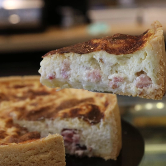 Produzida com nossa tradicional massa de tortas e quiches. O recheio é denso e cremoso, com pedaços de bacon e queijo parmesão. Esse é um sabor tradicional de quiches, muito comercializado em padarias artesanais francesas e com inspirações francesas aqui no Brasil.(Fatia pequena, aproximadamente 100g)