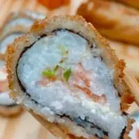 Delicie-se com nosso irresistível sushi de salmão! Preparado com filé de salmão fresco, cremoso cream cheese, arroz saboroso e uma crocante camada de alga, tudo envolto em uma crocante farinha panko que garante uma experiência única a cada mordida. Uma combinação perfeita de sabores e texturas que vai conquistar seu paladar! Experimente e surpreenda-se!