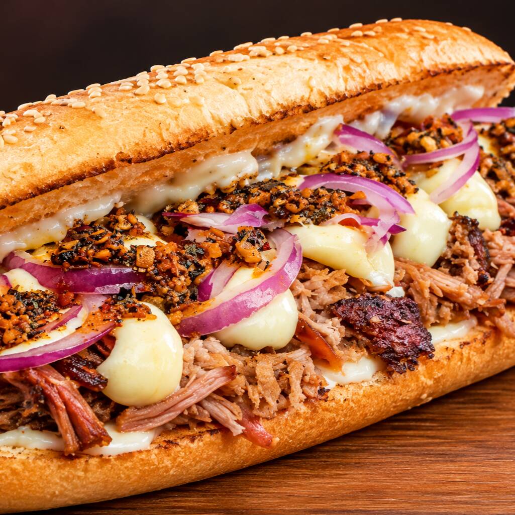 Baguete, cupim defumado e desfiado, molho chinichurri, queijo catupiry, maionese da casa, cebola roxa.