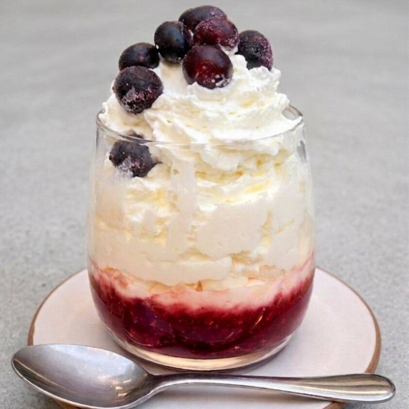 Calda de frutas vermelhas Tfc, iogurte natural integral ou zero lactose, suspiro tradicional sem adição de açucar, chantilly Tfc e mirtilo.
