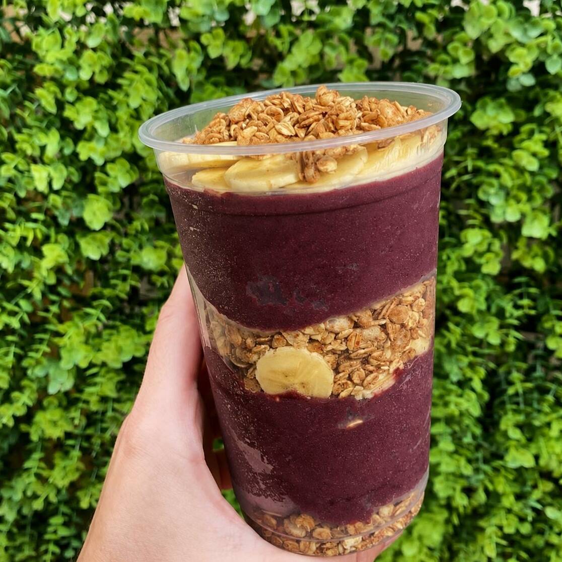 Açaí cremoso e refrescante, servido com banana e granola em quantidade generosa.