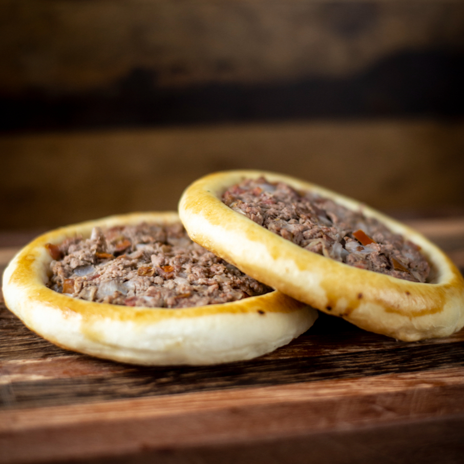 Massa artesanal aberta coberta com carne moída bovina temperada com especiarias.