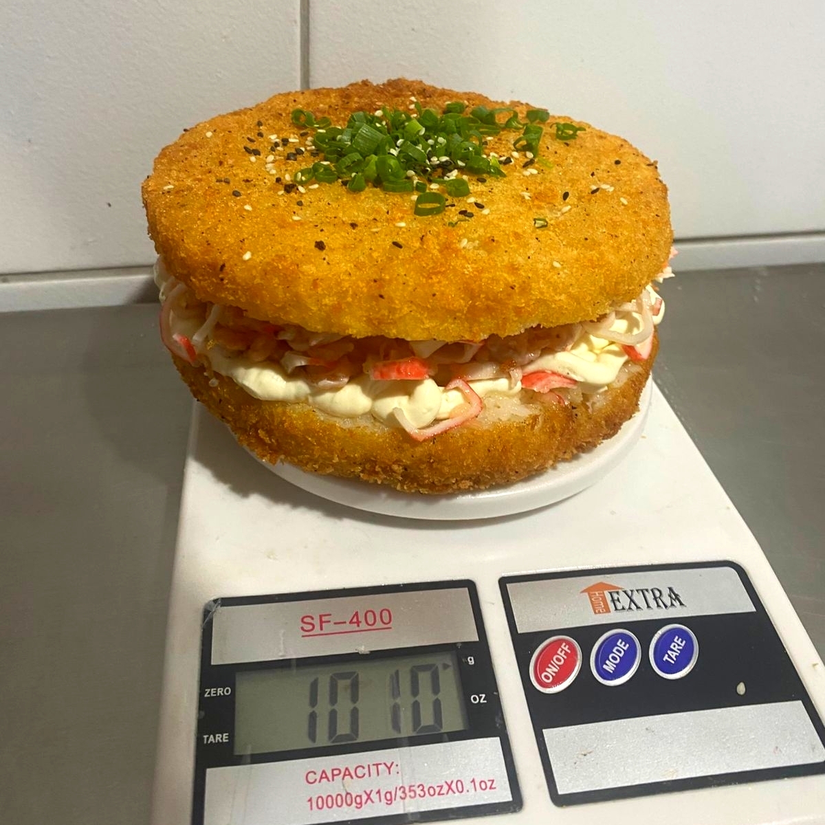 arroz japonês empanado e frito, cream cheese, e frutos que são: kani-kama(carne de carangueijo), camarão e salmão (cru), cebolinha e gergelim.