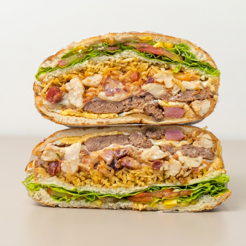 Filé de frango, hamburguer, mussarela, presunto, bacon, milho, Catupiry ou cheddar, batata palha, alface e tomate.