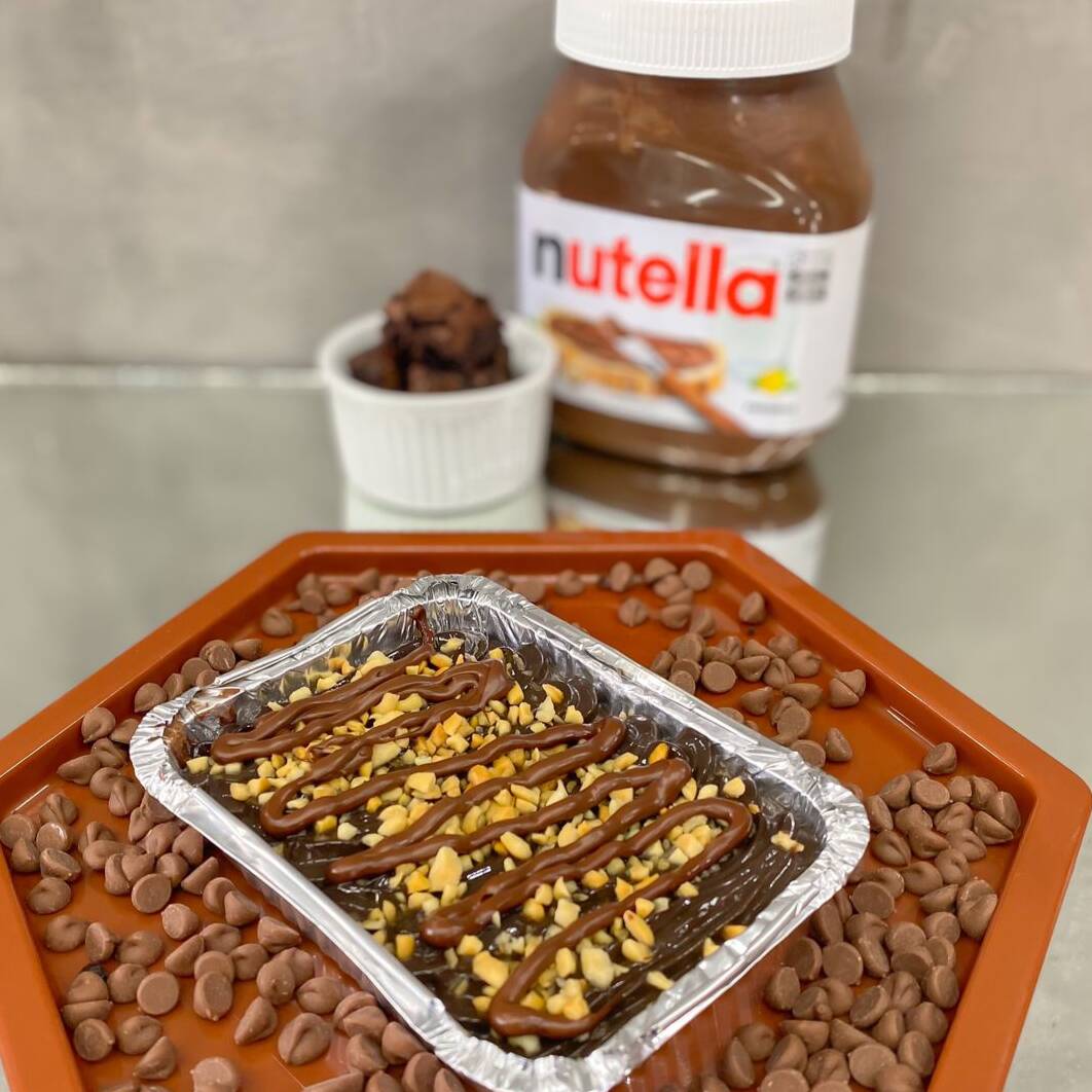 Brownie macio e intenso coberto com brigadeiro ao leite cremoso, Nutella e amendoim crocante. Muito sabor em cada colherada.