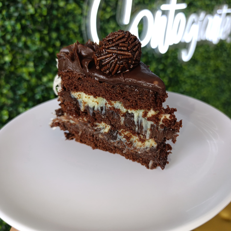 Massa de chocolate com recheio de brigadeiro e beijinho, com cobertura de ganache de chocolate. Peso da fatia 180g aproximadamente.