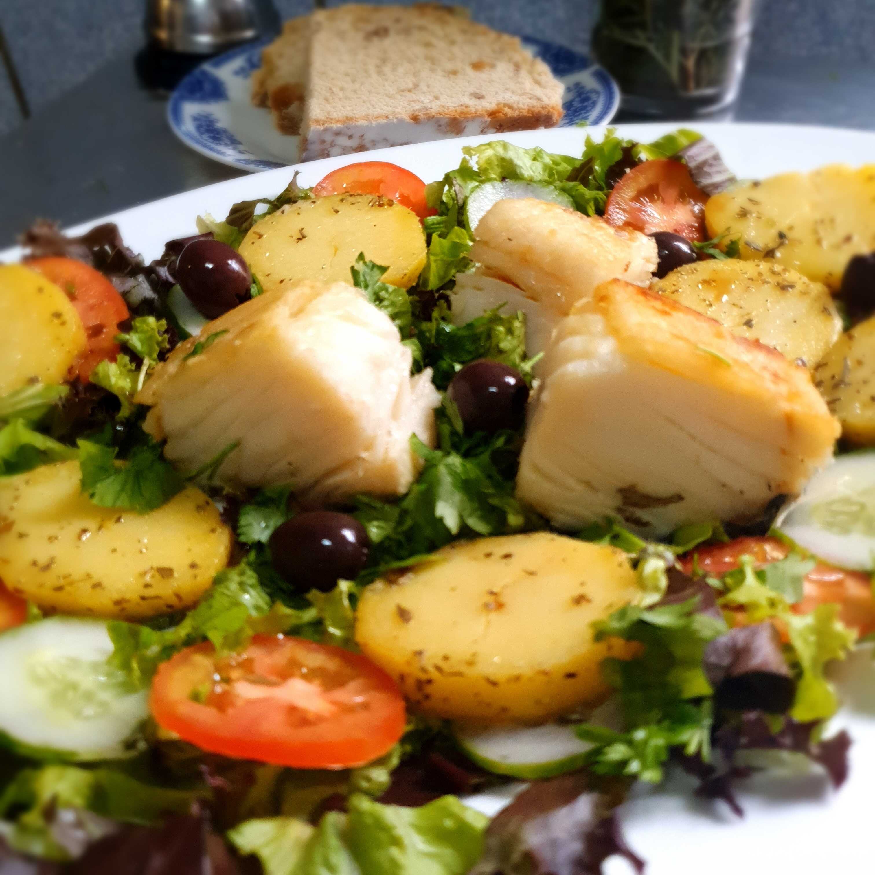 Lombo de bacalhau grelhado servido com salada e batata sauté. Acompanha pão caseiro. Serve 1 pessoa