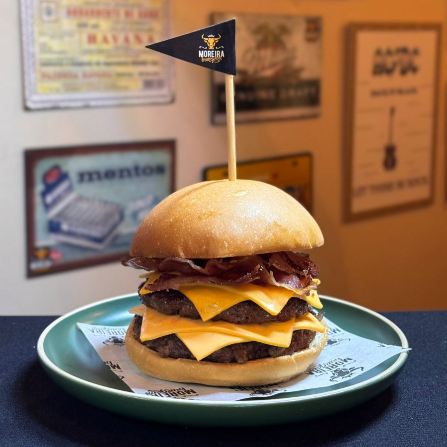 Dois Suculentos Burger Angus, Fatias de Queijo Cheddar Americano Entre as Carnes, Fatias de Bacon Crocante, Maionese, Ketchup.
Servido no Pão Levemente Selado