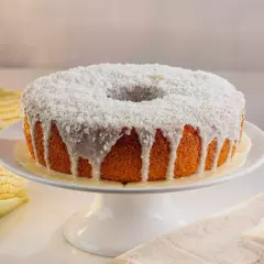 Delicioso Bolo de milho caseiro com coco ralado na massa. Opção de cobertura de: leite condensado, polvilhado com coco ralado. Imagem meramente ilustrativa.