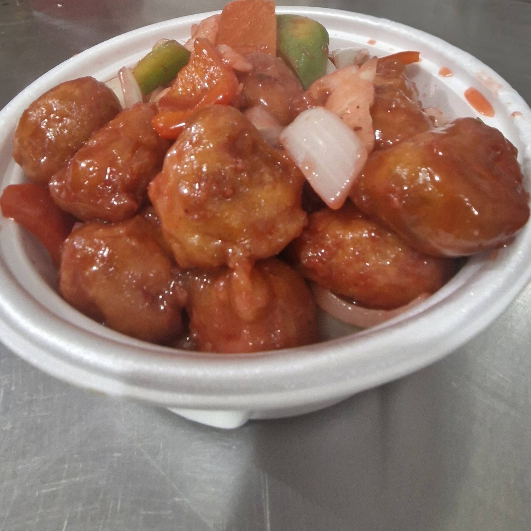 Cubos de lombo suíno empanado e frito com abacaxi ,cebola, pimentão verde e vermelho ao molho agridoce.