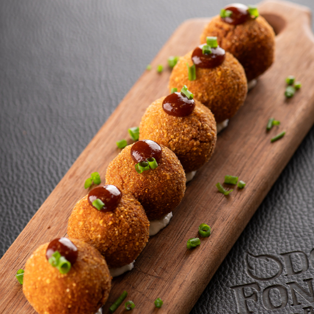 Deliciosos bolinhos de copa lombo desfiada, recheado com queijo minas, com duplo empanamento em corn flakes e finalizado com molho barbecue de goiabada. Crocantes e cremosos. (6 un)
