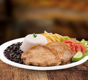 Duas bistecas suínas (120g cada - in natura) servidas com limão para o toque final. Acompanha arroz, feijão temperado, salada fresca, fritas crocantes e molho. Uma refeição generosa e equilibrada!