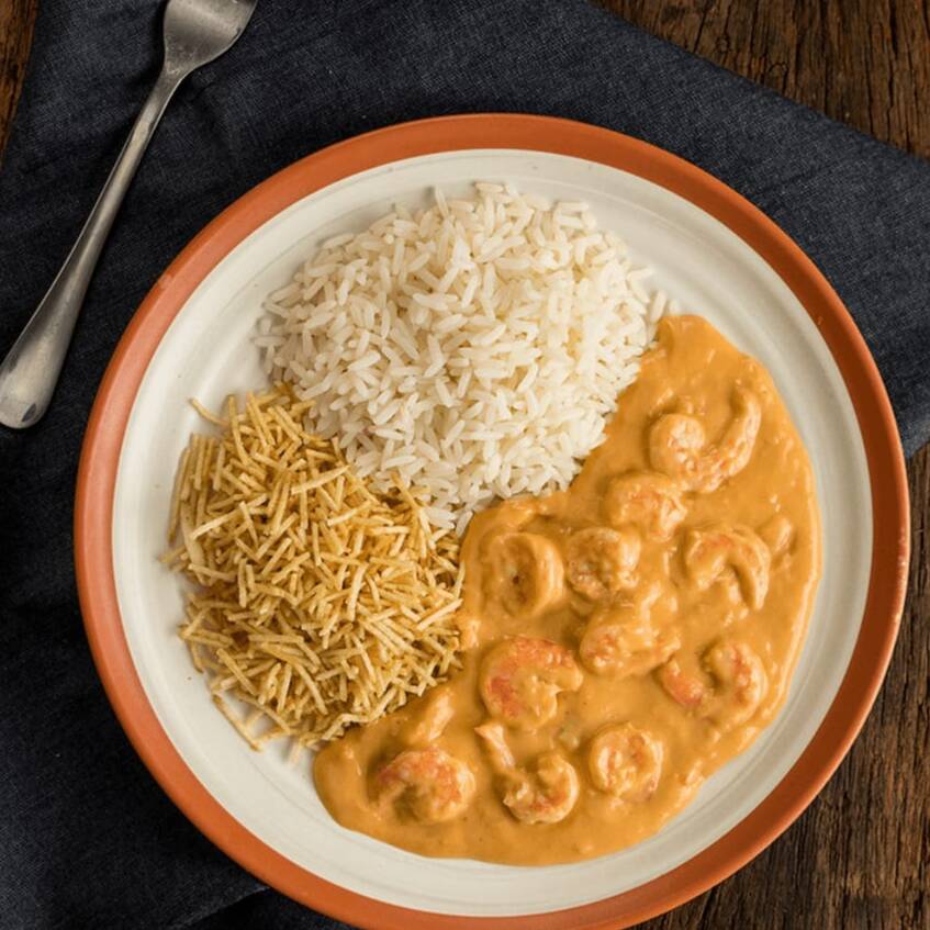 Estrogonofe de camarão com molho especial e creme de leite, acompanhado de arroz soltinho e batata palha.