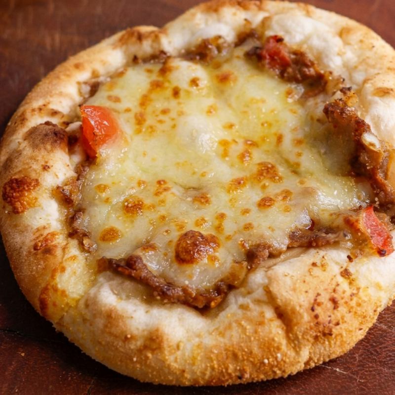Nossa esfiha de carne com queijo é suculenta, temperada na medida certa, com uma crostinha de queijo e assada com massa leve e douradinha. Cada mordida é um convite pra voltar…