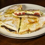 carne temperada com especiarias árabes no pão sírio artesanal, muçarela e tomate.