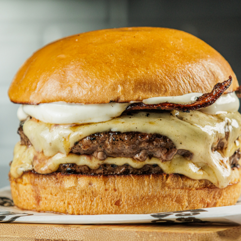 2blends bovinos 150g cada, delicioso pão artesanal, 2 fatias de queijo prato, 4 saborosas fatias de bacon e maionese farini.