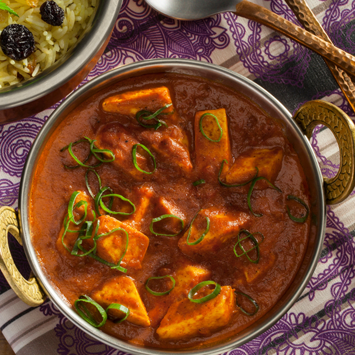 Cubos de ricota fresca marinados no iogurte com especiarias indianas, cozidos em molho de tomates frescos, manteiga e decorados com creme de leite. Diced fresh ricotta cheese marinated in yogurt and Indian spices, cooked in fresh tomatoes sauce and butter, then decorated with cream.