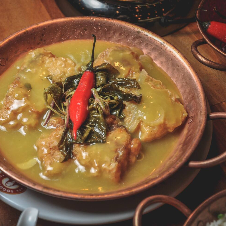 Filé de dourada empanado, servido sobre redução de creme de tucupi, acompanha arroz branco.