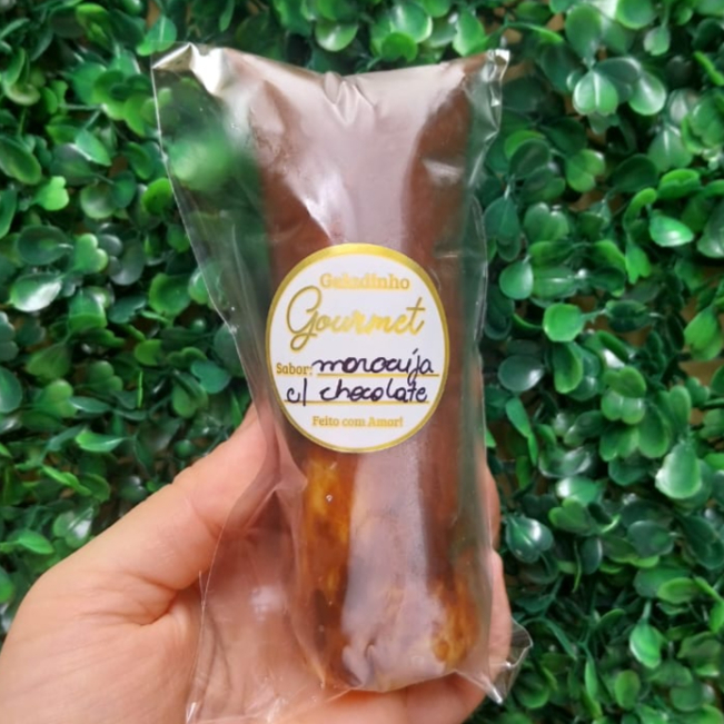 Geladinho Gourmet de Maracujá com Chocolate. Feito com a própria polpa do maracujá para deixar um sabor concentrado, com uma deliciosa casquinha de chocolate nobre ao leite para deixar ainda mais crocante e saboroso. Cremoso, gostoso e viciante pra você se refrescar! Obs. Aproximadamente 150ml.